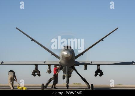 I manutentori di eseguire il preflight finale delle procedure prima di un MQ-9 Reaper, blocco 5 variante, prendendo il largo 23 giugno 2017, nel sud-ovest Asia. Questo ha segnato il blocco del primo volo di combattimento a sostegno di funzionamento inerenti a risolvere. Foto Stock