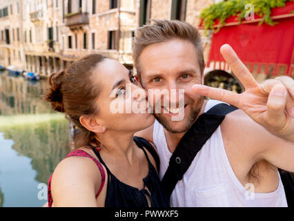Coppia felice prendendo un selfie con smart telefono cellulare nei canali di Venezia la famosa città europea in Italia in estate vacanze turismo viaggi ar Foto Stock