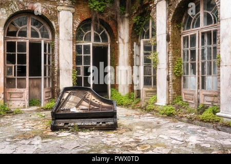 Rotture di pianoforte sdraiato sul pavimento nel cortile di un palazzo abbandonato in Polonia. Foto Stock