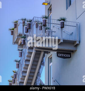 Le scale di un edificio per uffici con vasi di piante Foto Stock