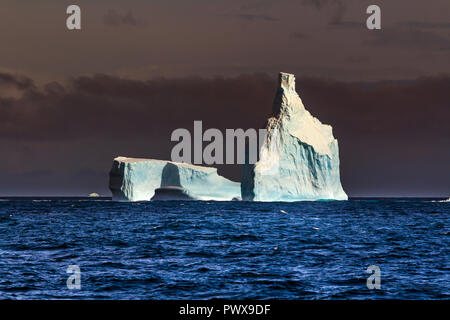 Iceberg galleggia sull'acqua aperto. È possibile vedere la parte subacquea di esso e il ghiaccio floes vicino ad essa. Antartico. Foto Stock