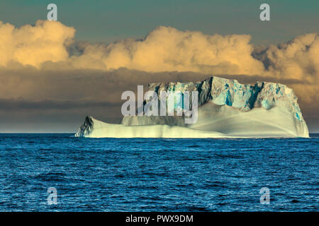 Iceberg galleggia sull'acqua aperto. È possibile vedere la parte subacquea di esso e il ghiaccio floes vicino ad essa. Antartico. Foto Stock