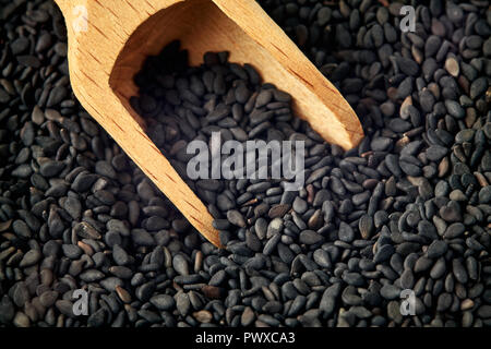 Close up di semi di sesamo nero in legno da convogliatore Foto Stock