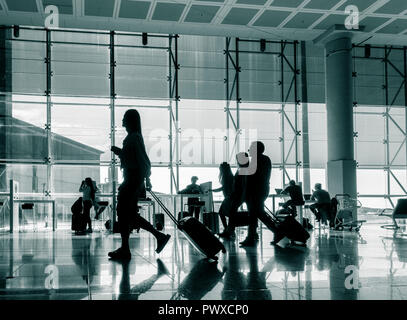 Persone che utilizzano dispositivi mobili e computer portatili in zona Wifi all'aeroporto El Prat di Barcellona. Spagna Foto Stock