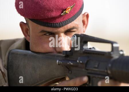 Un esercito iracheno soldier guarda giù i siti di sua M16 carbine durante la guerriglia urbana la formazione guidata da esercito portoghese formatori presso la gamma Besmaya complesso Luglio 2, 2017. Questa formazione fa parte del complesso di Combined Joint Task Force - Funzionamento inerenti risolvere la costruzione di capacità del partner di missione che si concentra sulla formazione e migliorare la capacità di partnership forze che lottano ISIS. CJTF-funzione OIR è la coalizione globale per sconfiggere ISIS in Iraq e la Siria. Foto Stock