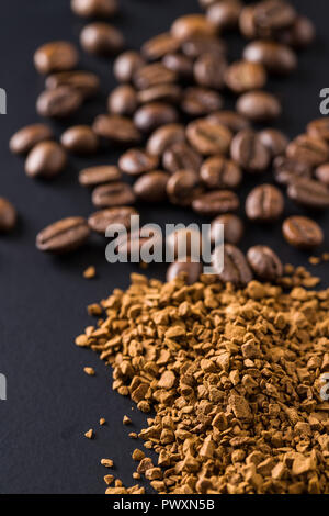 Il caffè istantaneo e i chicchi di caffè sulla tavola nera. Foto Stock
