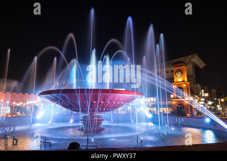 Accesa Nam Phou (PHU) Fontana e persone mangiare all'aperto nel centro di Vientiane, Laos, di notte. Foto Stock