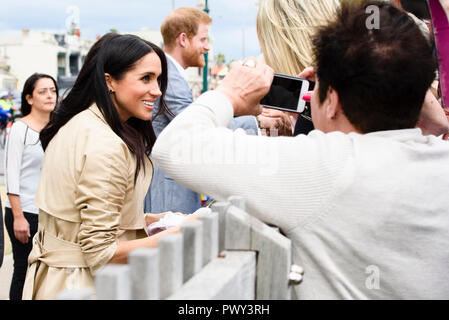 Melbourne, Australia. 18 ott 2018. Il Duca e la Duchessa di Sussex visitare Melbourne, Australia 18 Ott 2018 Meghan accetta un dono di un rosa baby vestito da un pozzo wisher. Credito: Robyn Charnley/Alamy Live News Foto Stock