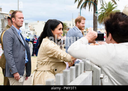 Melbourne, Australia. 18 ott 2018. Il Duca e la Duchessa di Sussex visitare Melbourne, Australia 18 Ott 2018 Meghan accetta un dono di un rosa baby vestito da un pozzo wisher. Credito: Robyn Charnley/Alamy Live News Foto Stock