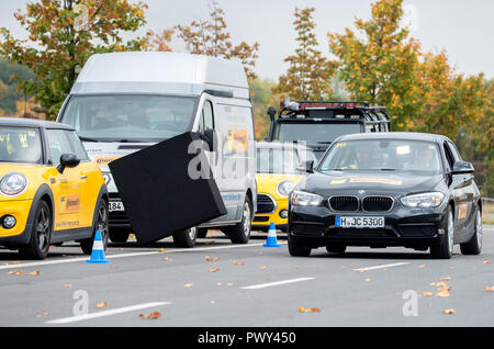 Laatzen, Germania. Xviii oct, 2018. Jörg Bode, vice leader di fazione e di politica dei trasporti il portavoce della FDP, unità sulla pratica area dell'ADAC guida centro di sicurezza con uno smartphone nella sua mano attraverso un corso in cui un oggetto viene lanciata sulla via. Durante il viaggio, deve essere dimostrato che l'uso di un semaforo app previsto dalla città di Hannover potrebbe essere associato con un elevato rischio di incidenti. ADAC, FDP, Camera dei mestieri e le associazioni imprenditoriali (UVN) opporsi all'introduzione dell'App. Credito: Hauke-Christian Dittrich/dpa/Alamy Live News Foto Stock