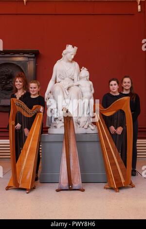 Cork, Irlanda. Xviii oct, 2018. Nella foto qui (LtoR) è Abigal Walsh, Aoife Aheran, Kellyanne francese, Eimear Mc Donaghstanding davanti alla statua di William Crawford con le loro cetre. Preparazioni per arpa nazionali giorno/ Lá na Cruite, Cork City. Con Arpa nazionali giorno/ Lá na Cruite svolge questo sabato preparati hanno iniziato nella città di Cork. . Credito: Damian Coleman/Alamy Live News Foto Stock