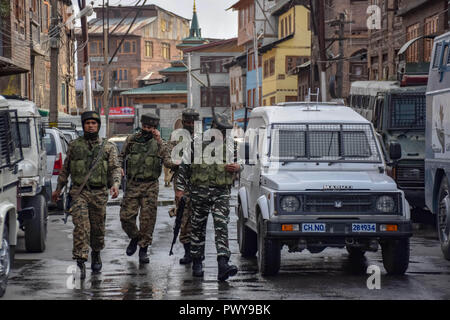 Ottobre 17, 2018 - Srinagar, Jammu e Kashmir - Poliziotti indiani sono visto visto ispezione intorno a pistola di battaglia sito.Indian poliziotti pattugliano la zona dopo gli scontri del anti-protesta che è scoppiata nella città principale nella disputa sul Kashmir dopo una pistola battaglia tra militanti e forze di governo che ha ucciso almeno altri due sospetti ribelli e un civile e un counterinsurgency ufficiali di polizia. Credito: Idrees Abbas SOPA/images/ZUMA filo/Alamy Live News Foto Stock