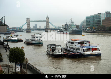 E turistico parte barche ormeggiate nel fiume Tamigi con HMS Belfast e il Tower Bridge in background Londra Inghilterra Regno Unito Regno Unito Foto Stock