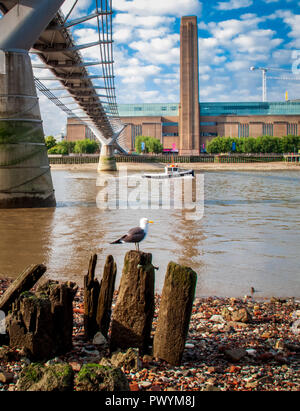 Al di sotto del Millennium bridge Fiume Tamigi con la bassa marea, guardando verso la Tate Modern Foto Stock