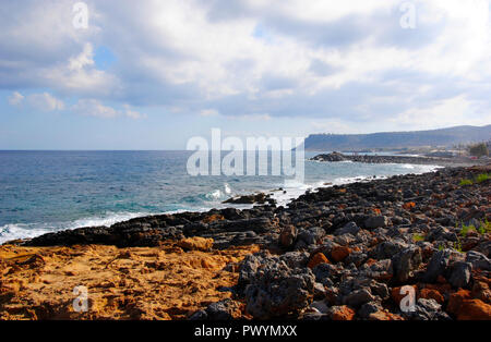 Le onde che si infrangono al red costa rocciosa di Sissi a Creta in Grecia Foto Stock