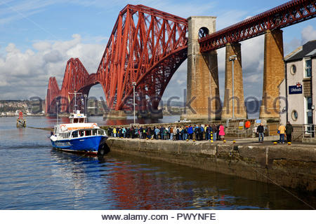 I turisti che fanno la fila al Forth Bridge si uniscono al Forth Belle Boat Tour del Forth Estuary e delle isole di South Queensferry, Scozia Foto Stock