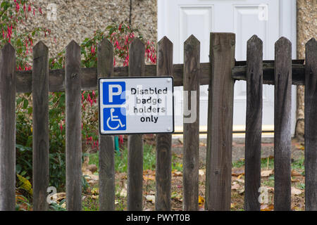 Badge disabili titolari solo segno su una recinzione al di fuori di una casa in Hampshire, Regno Unito. Parcheggio Disabili segnaletica di spazio. Foto Stock