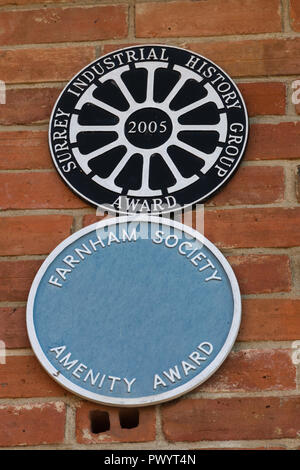 Le placche sul muro esterno di Farnham ceramiche, Wrecclesham, Surrey, Regno Unito. Surrey storia industriale del Gruppo e società di Farnham amenità Awards. Foto Stock