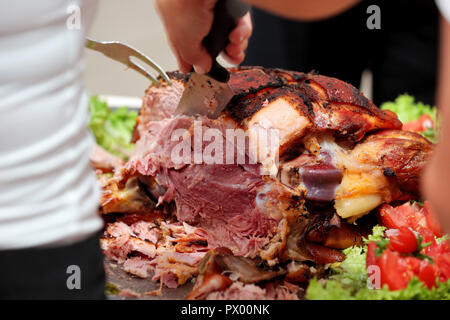 Cameriere serve arrosti di carne e patate al forno al partito o ricevimento di nozze Foto Stock