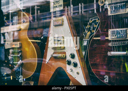 Hanks chitarre acustiche. Vecchio chitarre in vetrina del negozio, Tin Pan Alley / Denmark Street a Londra, Inghilterra. Vintage filtro applicato Foto Stock