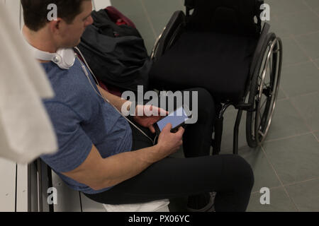 Disabilitato l'uomo utilizzando il telefono cellulare Foto Stock