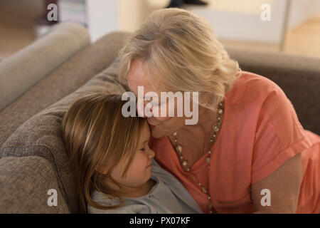 Nonna baciando la sua nipote in salotto Foto Stock