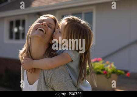 Madre dando piggyback ride a sua figlia nel portico Foto Stock