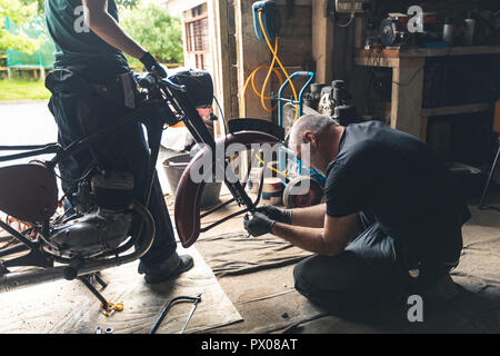 Riparazione meccanica moto nel garage Foto Stock