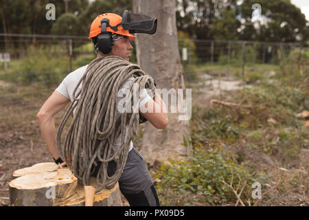 Lumberjack rilassante sul ceppo di albero nella foresta Foto Stock