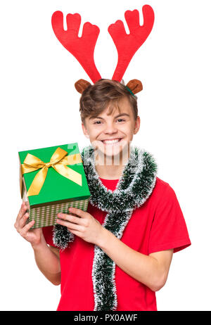 Ritratto di sorridere teen boy con divertenti Natale corna di cervo. Adolescente azienda confezione regalo. Concetto di vacanza - happy carino bambino isolato su bianco b Foto Stock