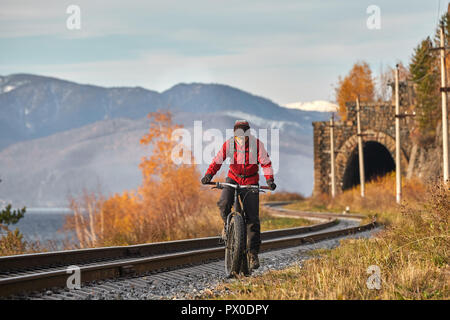 Gite turistiche una bici con ruote larghe lungo la riva del lago Baikal. Autunno in Siberia. Foto Stock