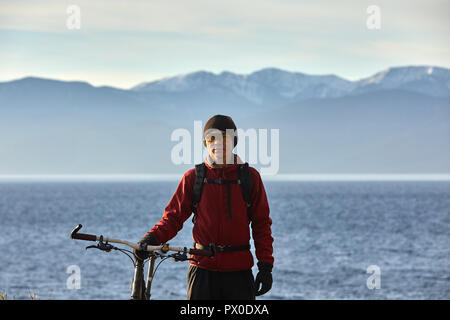 Gite turistiche una bici con ruote larghe lungo la riva del lago Baikal. Autunno in Siberia. Foto Stock