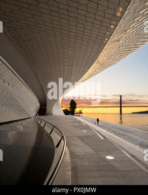 Vista esterna del MAAT - Museo di Arte, Architettura e Tecnologia, Lisbona, Portogallo. Vista lungo la terrazza sul fiume a suset. Foto Stock