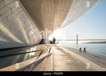 Vista esterna del MAAT - Museo di Arte, Architettura e Tecnologia, Lisbona, Portogallo. I ciclisti sulla riva. Foto Stock