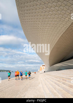 Vista esterna del MAAT - Museo di Arte, Architettura e Tecnologia, Lisbona, Portogallo. Gruppo di praticanti di jogging sui gradini della terrazza. Foto Stock