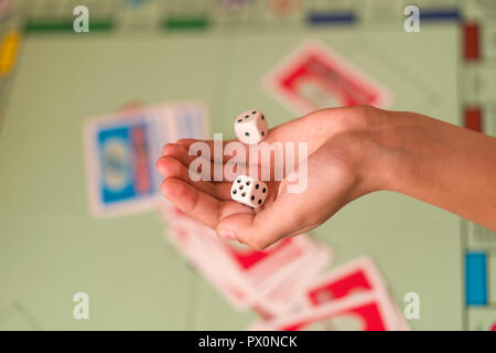 La mano lanci di dadi di gioco sullo sfondo del campo di gioco. l uomo trattiene il dado. Mano con dadi. Foto Stock