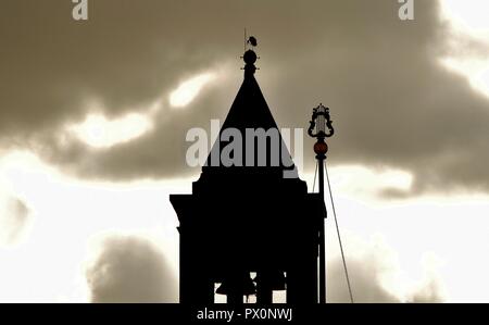 Silhouette di cicogna bianca, Ciconia ciconia, migrazione oltre le isole maltesi. Uccello è in appoggio sul bilanciamento del campanile della Chiesa Cattolica, Malta Foto Stock