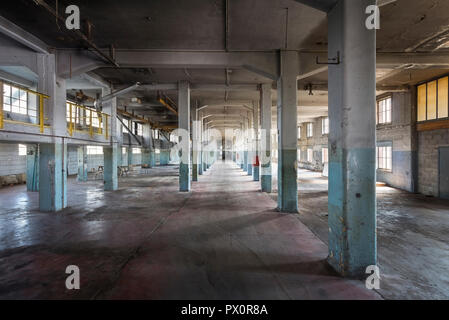 Vista interna di una grande hall con pilastri in un abbandonato la fabbrica di cioccolato in Belgio. Foto Stock