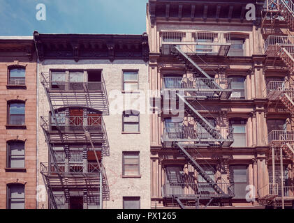 Gli edifici di vecchia costruzione con il fuoco sfugge, uno dei New York City simboli, tonificazione vintage applicata, Stati Uniti d'America. Foto Stock