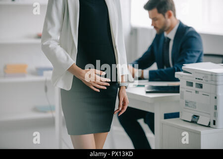 Vista parziale di gravidanza imprenditrice e collega al lavoro in ufficio Foto Stock