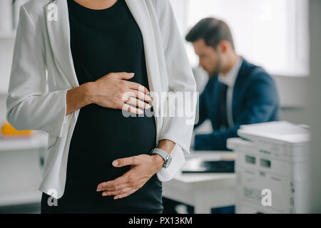 Vista parziale di gravidanza imprenditrice e collega al lavoro in ufficio Foto Stock