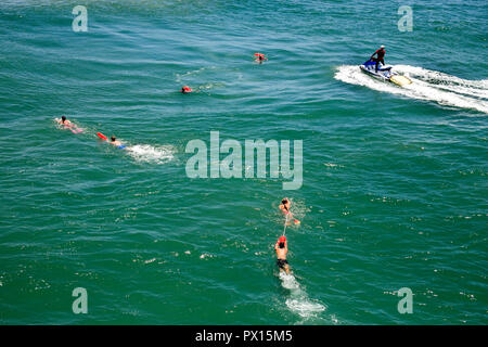 Un aiuto al salvataggio di natanti arriva per una vittima di annegamento e bagnino di Huntington Beach, CA. Foto Stock