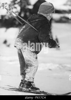 Inverno negli anni sessanta. Un ragazzo è lo sci. Con gli sguardi della neve sui suoi vestiti, è caduto molte volte. La Svezia degli anni sessanta Foto Stock