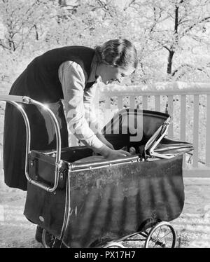 Madre con bambino nel 1940s. La sig.ra Norrby con sua figlia Margareta in un passeggino su un giorno inverni. La Svezia 1942 Foto Stock