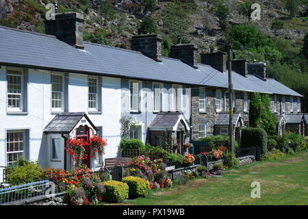 Fila di case a schiera, che si affaccia sul verde villaggio, Beddgelert, Gwynedd, Snowdonia, il Galles del Nord, Regno Unito Foto Stock