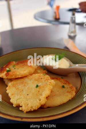 Guarnito frittelle di patate antipasto con panna acida nella piazza della città in Kedainiai, Lituania Foto Stock