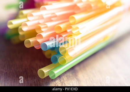 Macro di un Mazzetto colorato cannucce potabile su una tavola di legno Foto Stock