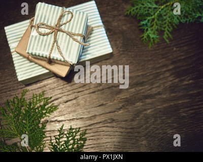 Layout creativo fatto di albero di Natale rami con doni. Lay piatto Foto Stock