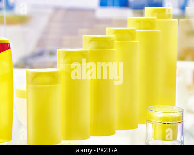 Le bottiglie di plastica di shampoo e jar per uso cosmetico sulla vetrina negozio Foto Stock