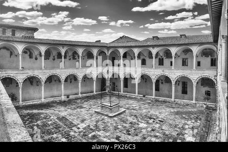 Vista panoramica con lo scenografico cortile nel convento della Basilica di San Francesco, Assisi, Italia. Del Patrimonio mondiale UNESCO dal 2000 Foto Stock